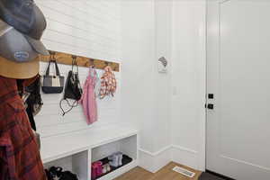 Mudroom with wooden walls and wood finished floors