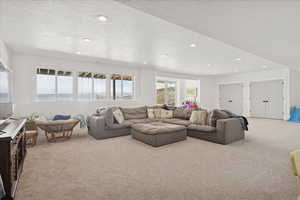 Living room featuring carpet, a textured ceiling, and recessed lighting