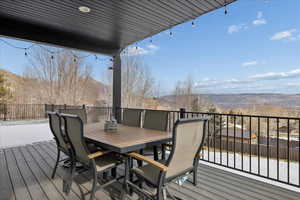 Wooden deck featuring a mountain view and outdoor dining area