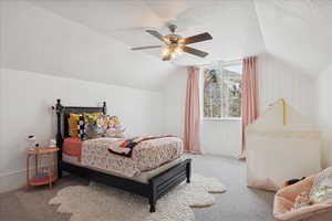 Bedroom featuring carpet floors, a textured ceiling, vaulted ceiling, and ceiling fan