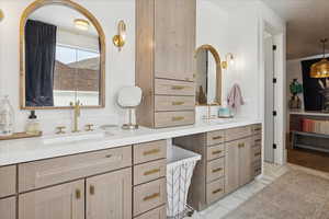 Bathroom with double vanity and light marble finish flooring