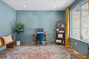 Office area with a decorative wall, recessed lighting, and wood finished floors