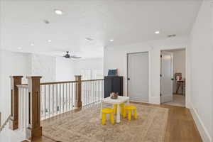 Sitting room featuring light wood-type flooring, a textured ceiling, and recessed lighting