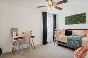 Carpeted bedroom with a ceiling fan and baseboards