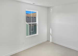 Spare room featuring baseboards and carpet floors