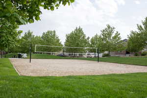 View of property's community with a lawn and volleyball court