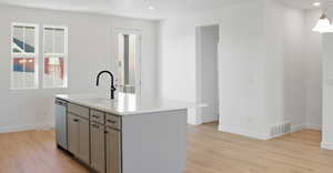 Kitchen with gray cabinetry, recessed lighting, an island with sink, light wood-style flooring, and stainless steel dishwasher