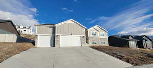 View of front of house featuring stone siding, board and batten siding, a garage, and concrete driveway