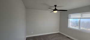 Bedroom with dark carpet and ceiling fan