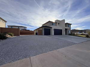 Contemporary house featuring concrete driveway, stucco siding, and a garage