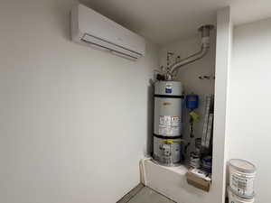 Utility room with a wall unit AC and water heater