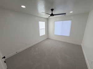 Empty room featuring a textured ceiling, recessed lighting, carpet floors, and a ceiling fan