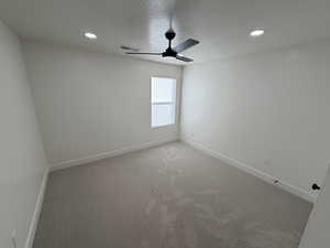 Unfurnished room featuring a textured ceiling, recessed lighting, light colored carpet, and ceiling fan