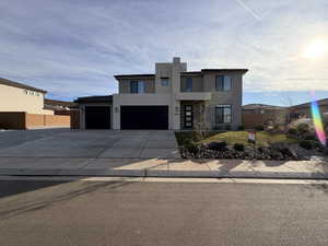 Contemporary home featuring stucco siding, driveway, and a tile roof