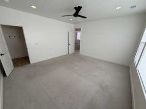 Unfurnished bedroom with a textured ceiling, a ceiling fan, light carpet, and recessed lighting