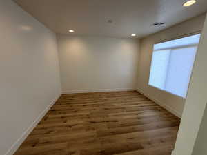 Unfurnished room with recessed lighting, light wood-type flooring, and a textured ceiling