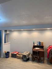 Recessed lighting illuminating smooth walls, wood-finish flooring, and a low wall partition