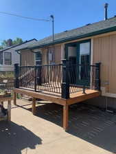 Elevated wood deck featuring decorative black metal railings