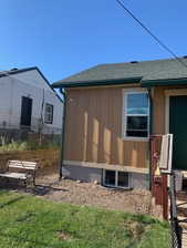 Exterior featuring vertical siding and a visible basement window