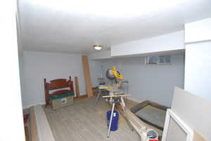 Bedroom with light wood-type flooring and a textured ceiling