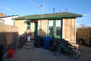 Back of property with roof with shingles, board and batten siding, a patio area, and entry steps