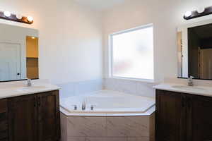 Bathroom with two vanities and a bath