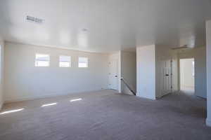 Empty room featuring carpet and baseboards