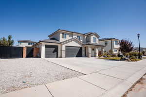 View of front of property featuring a gate, concrete driveway, a tiled roof, stone siding, and a garage