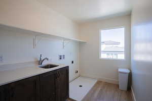 Washroom with washer hookup, light wood-style floors, and electric dryer hookup
