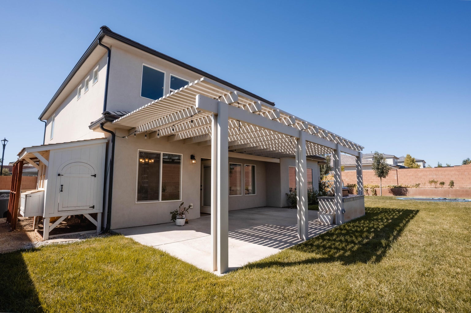 Back of house featuring a pergola, stucco siding, and a patio area