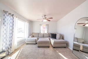 Living room with a ceiling fan and light colored carpet