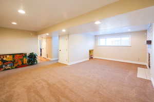 Basement with recessed lighting, light carpet, and a fireplace