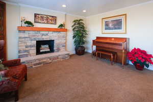 Living area with carpet flooring, a fireplace, crown molding, and recessed lighting