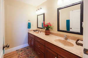 Bathroom with double vanity and baseboards