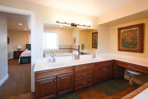 Full bathroom featuring ensuite bathroom, double vanity, and dark colored carpet