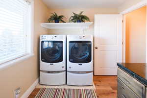 Laundry room with light wood-style floors and separate washer and dryer