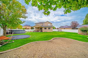 Back of house featuring a patio, a fenced backyard, and a trampoline