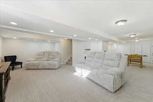Living room featuring light carpet, stairway, and recessed lighting