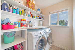 Washroom with washer and clothes dryer and light tile patterned floors