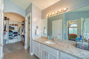 Ensuite bathroom featuring vanity and a spacious closet