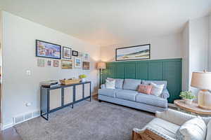 Carpeted living area featuring baseboards
