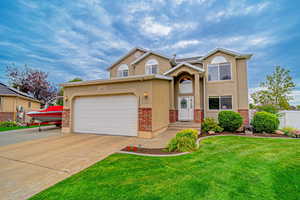 Traditional home featuring stucco siding, concrete driveway, and brick siding