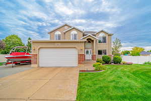 Traditional home with stucco siding, driveway, and brick siding