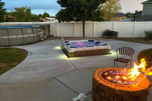 Fenced backyard with a fire pit and a patio