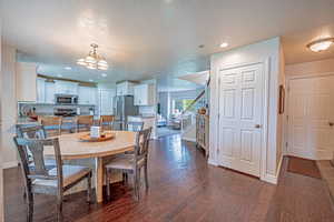 Dining area with recessed lighting, stairway, a textured ceiling, dark wood-style floors, and a chandelier