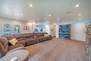 Carpeted living area with a textured ceiling and recessed lighting
