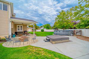 Fenced backyard featuring a patio, a fire pit, ceiling fan, and a shed