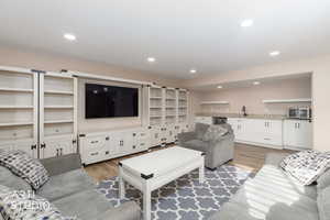 Large open living room and kitchen with recessed lighting.