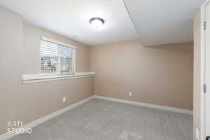 Bedroom 6 with light colored carpet and a textured ceiling.