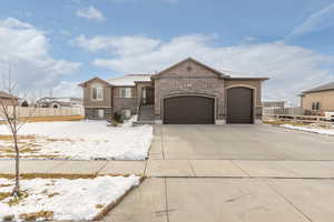 View of front of property featuring brick siding, a garage, and driveway